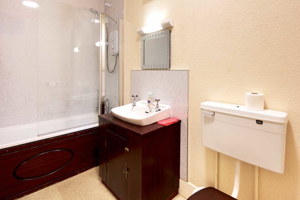 Light bathroom with shower bath, sink and toilet
